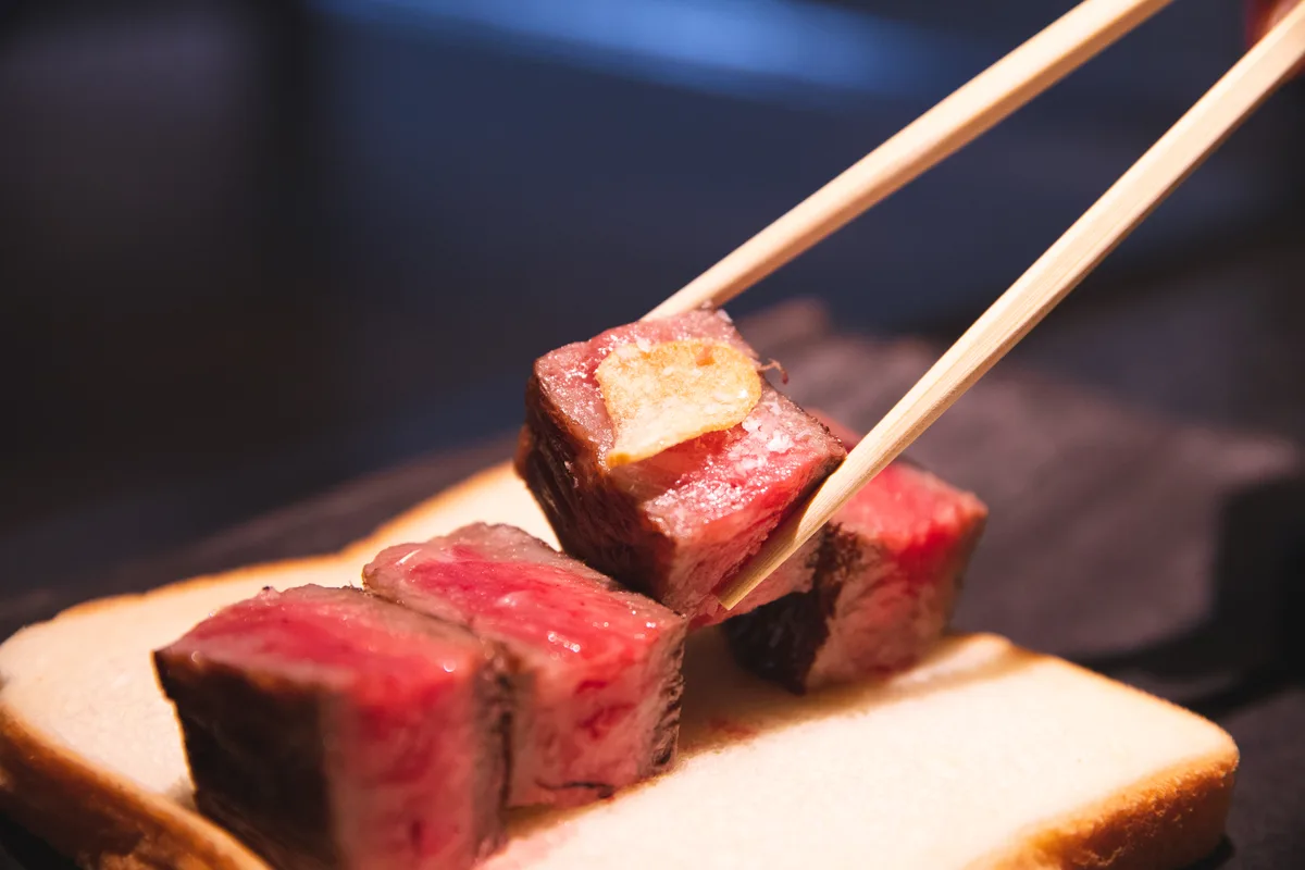宮崎牛を箸で持ち上げたステーキ料理（写真提供: 宮崎県観光協会）